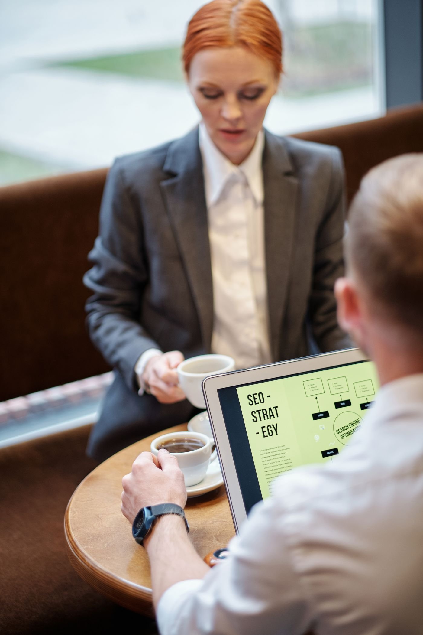 Two colleagues reviewing a plan together around a laptop in a real meeting.