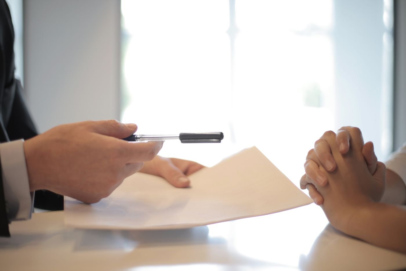 A contract being handed over for signature, a reminder to read the small details first.