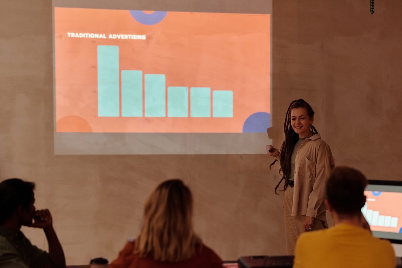 A presenter explaining a chart to a team, showing how a report should lead to a decision.