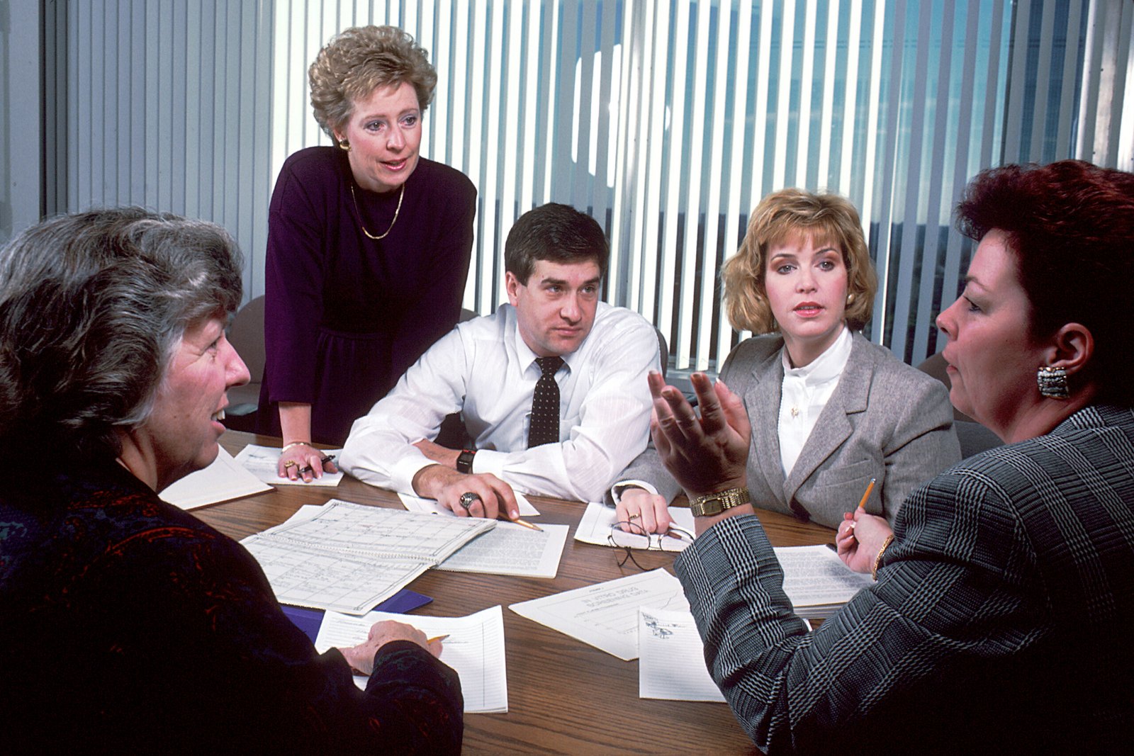 Colleagues working together around an office conference table