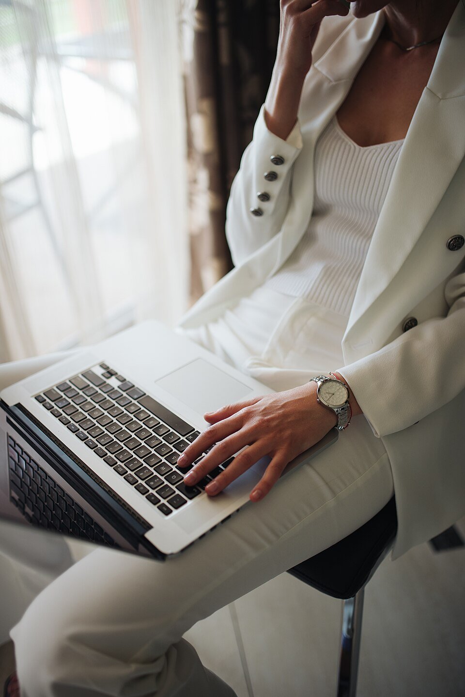 A business professional thinking while working on a laptop