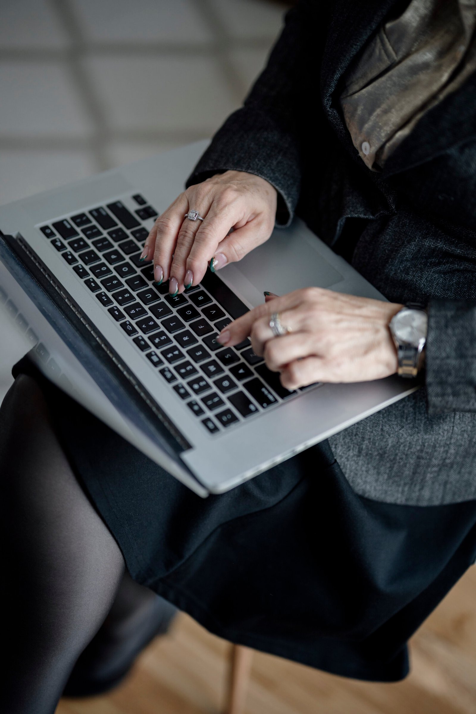 Hands typing on a laptop in a modern office