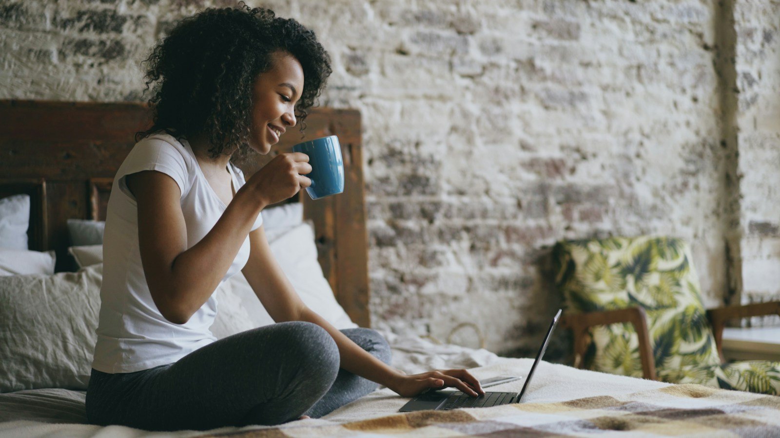 A person using a laptop with coffee in a relaxed room