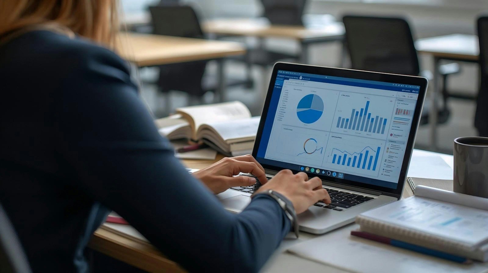 A woman reviewing charts and graphs on a laptop