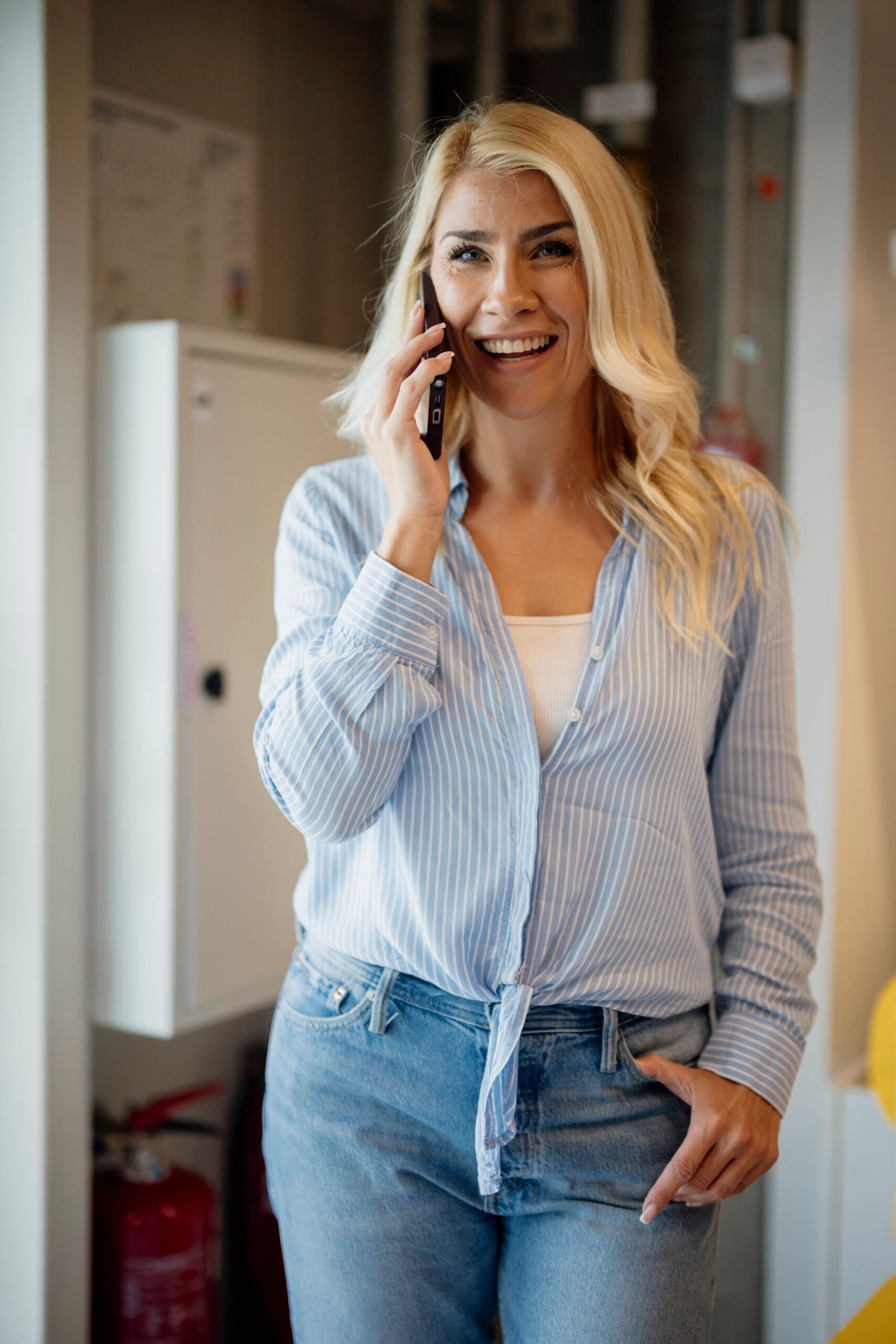 A woman talking on a smartphone in a modern office